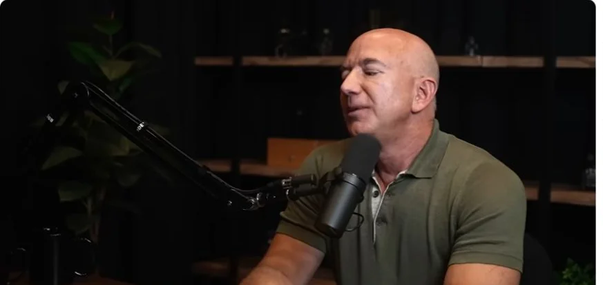 Jeff Bezos speaking into a microphone on the Lex Fridman Podcast