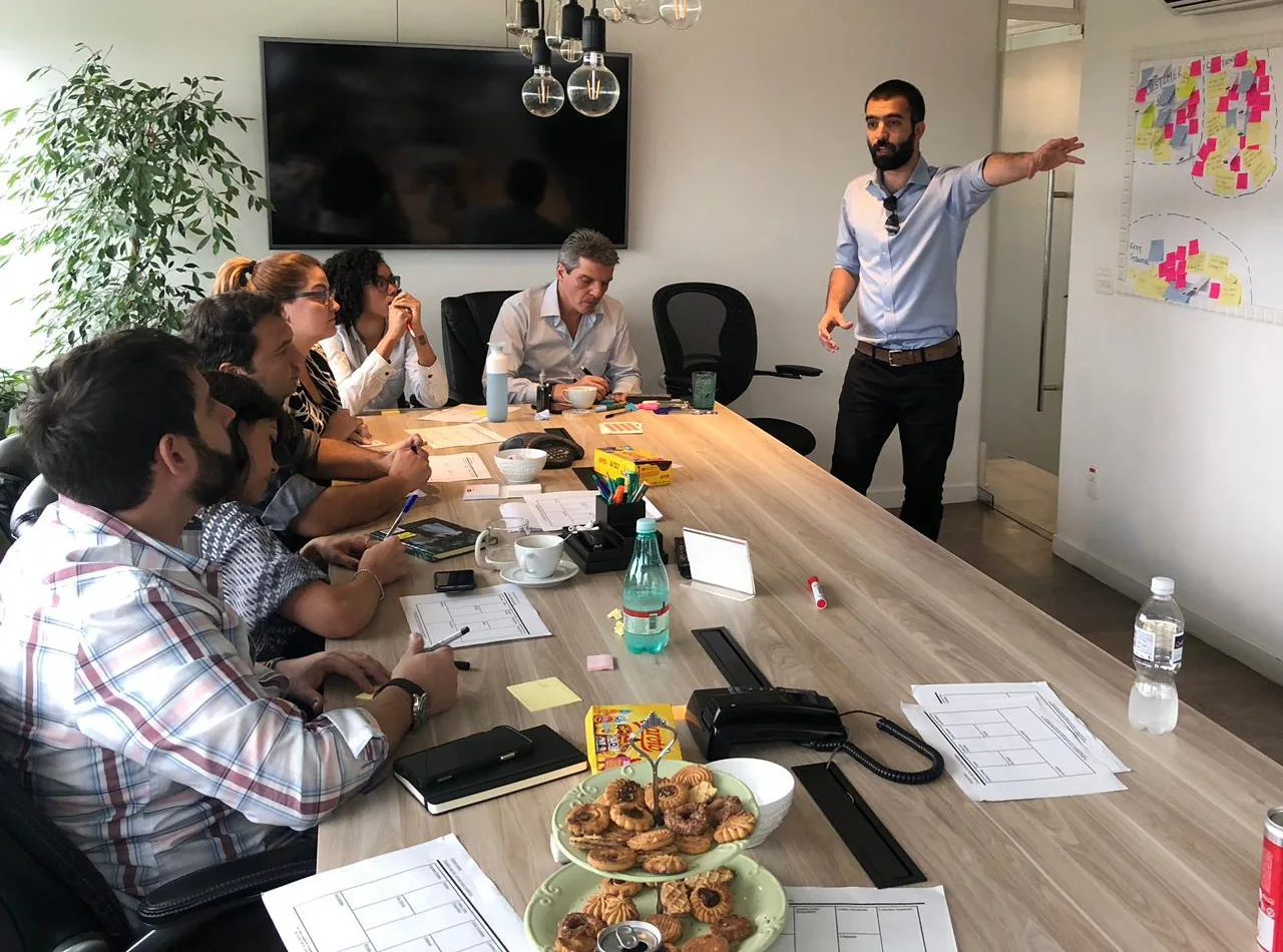Saad and colleagues working together around a table and whiteboard